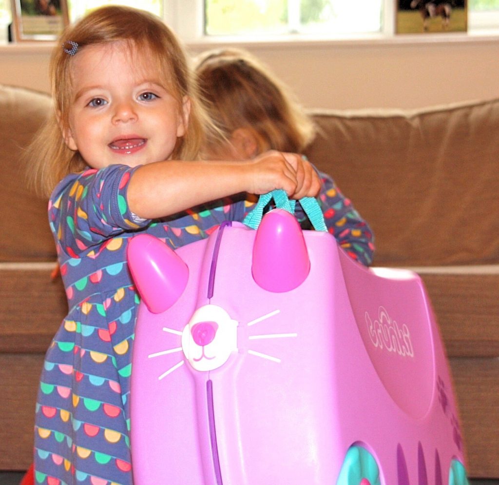 child carrying a Purple cat Trunki children's carry case