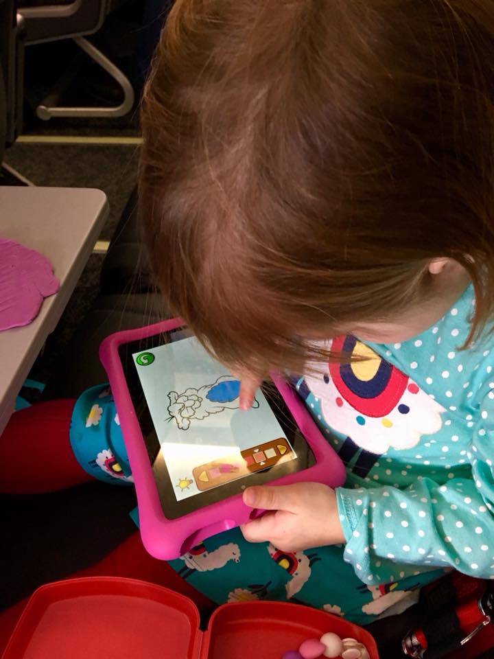 child paling on her kindle in the airplane