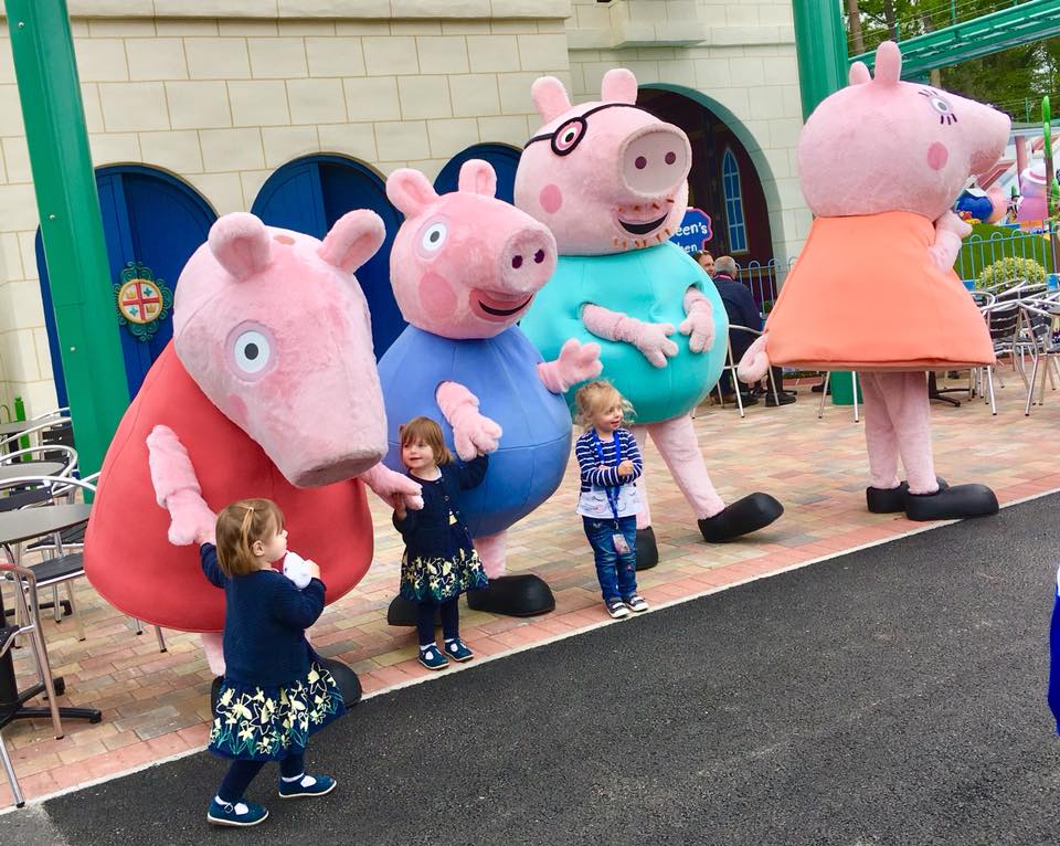 Twins at Peppa Pig World playing and smiling with the characters
