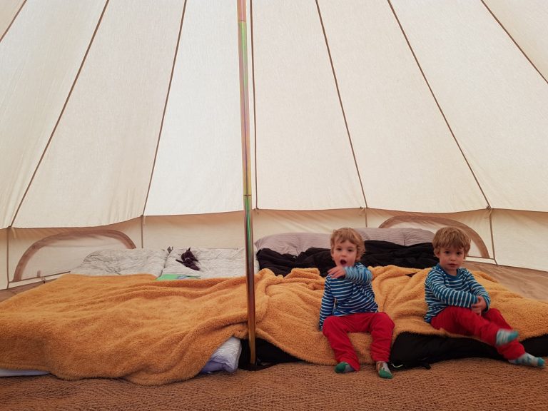 Twin boys sat inside tipi tent