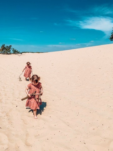 Dunes of Loon and Drunen National Park. Twins running in the sand. A great place to visit in Holland with kids.