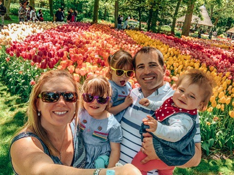 Keukonhof Tulip gardens in Holland. A family in front of a tulip bed. A great place to visit in Holland with kids.