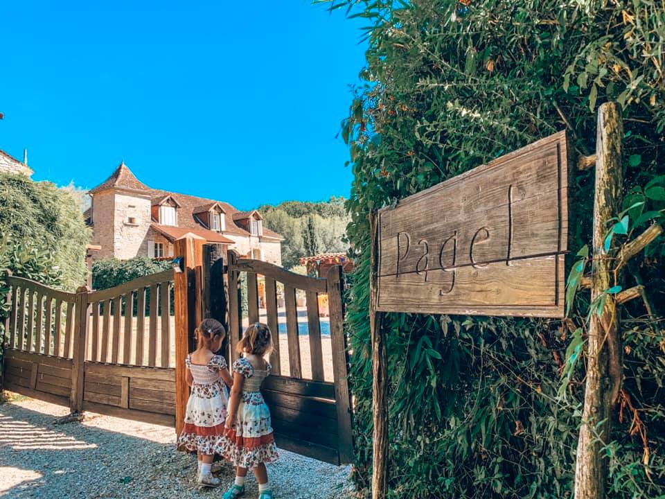 twins standing at the property sign of their holiday