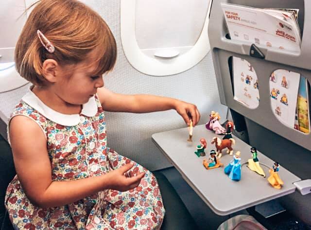 child playing with Disney figures on the airplane