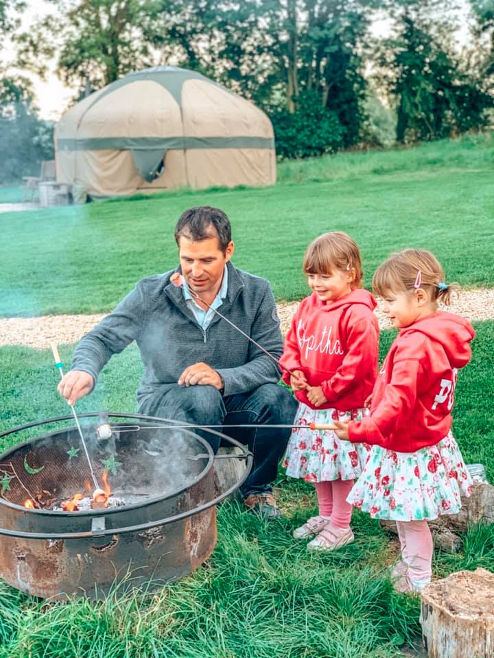 daddy and children round the campfire toasting Marshmallows