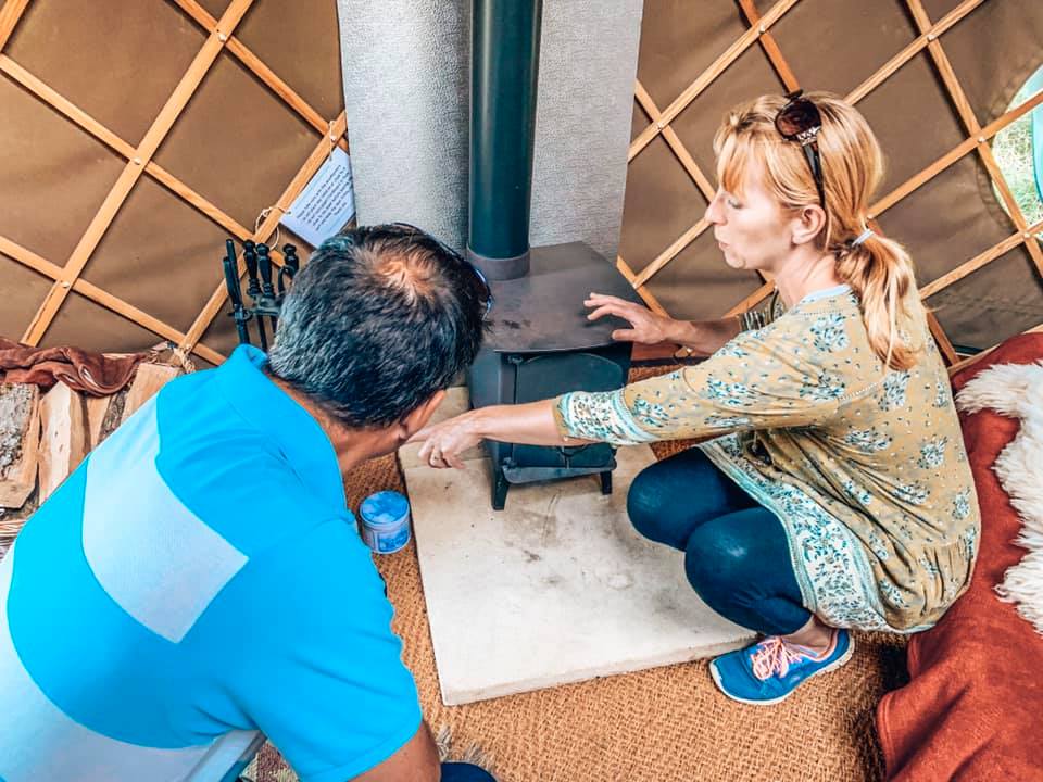 A lady showing guests how to work the log burner