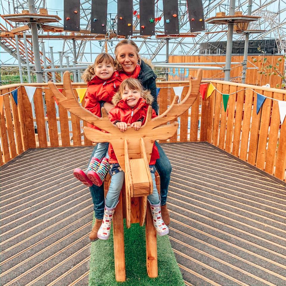 Riding a wooden reindeer inside the Serendome at Bluestone Wales