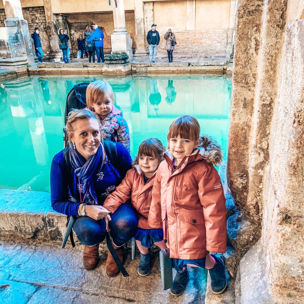 Twins and mum smiling in front of the roman baths. A great day out if in Bath with kids