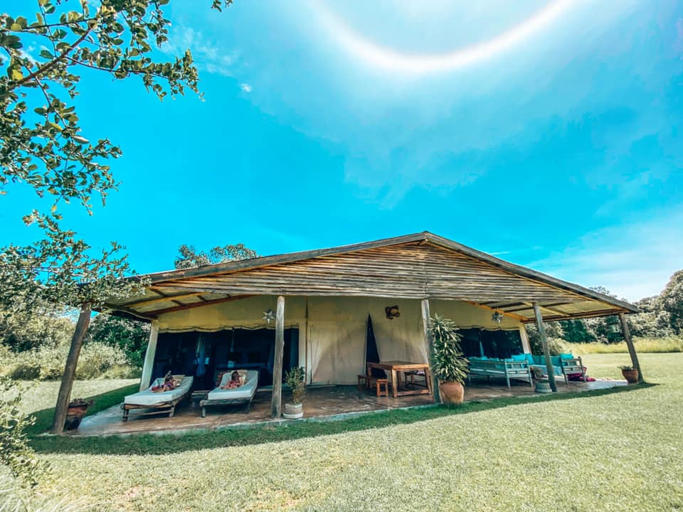 view of the Marula cottage from he outside with outdoor living space, loungers and lawn