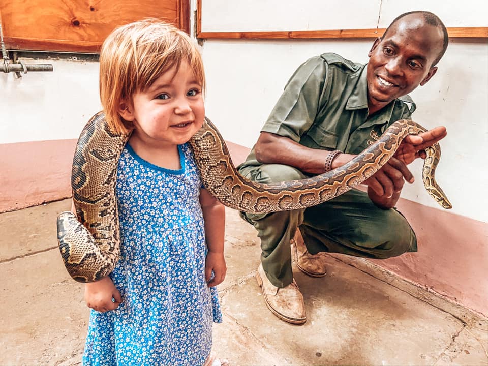 girl holding a snake around neck along side park ranger