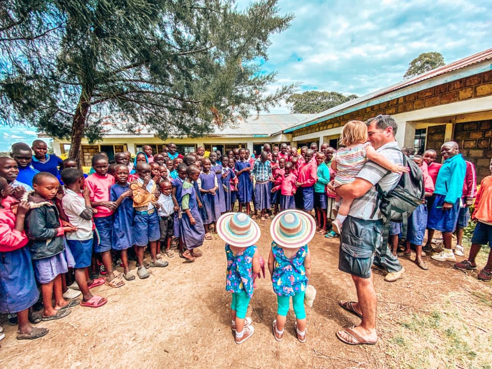 family surrounded by members of the school in Maasai Mara with Kids