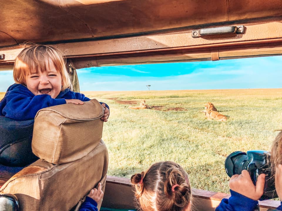 onboard a jeep on safari in Maasai Mara with Kids looking at lions