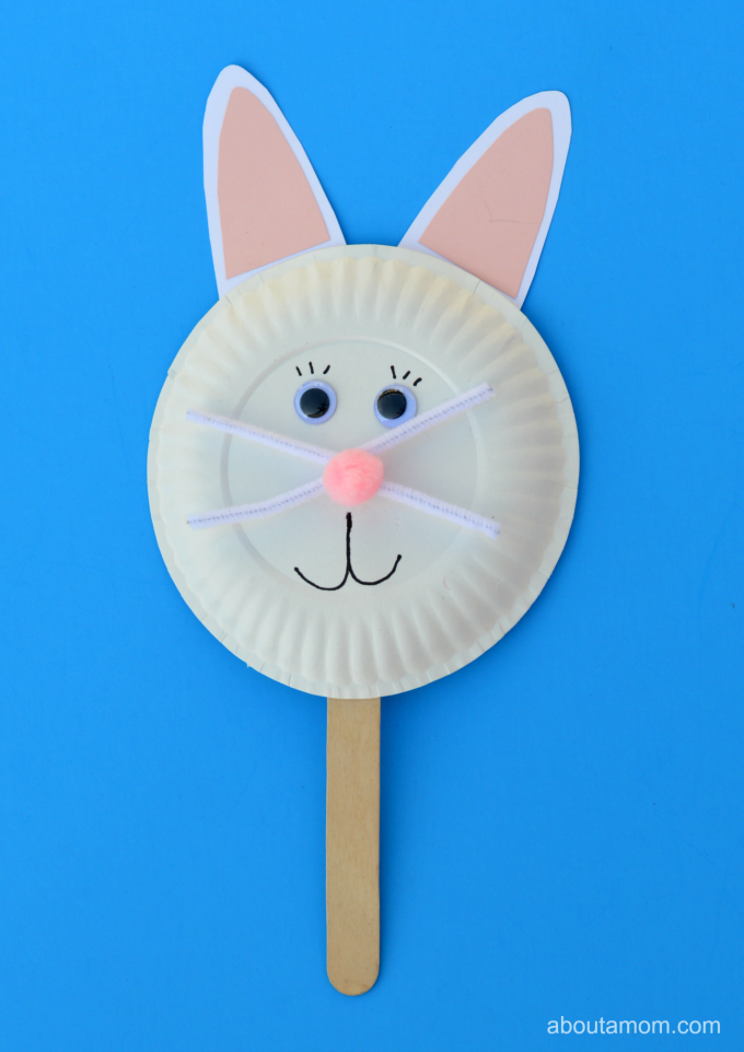 Easter bunny puppet made out of a white paper plate stuck onto a lolly stick