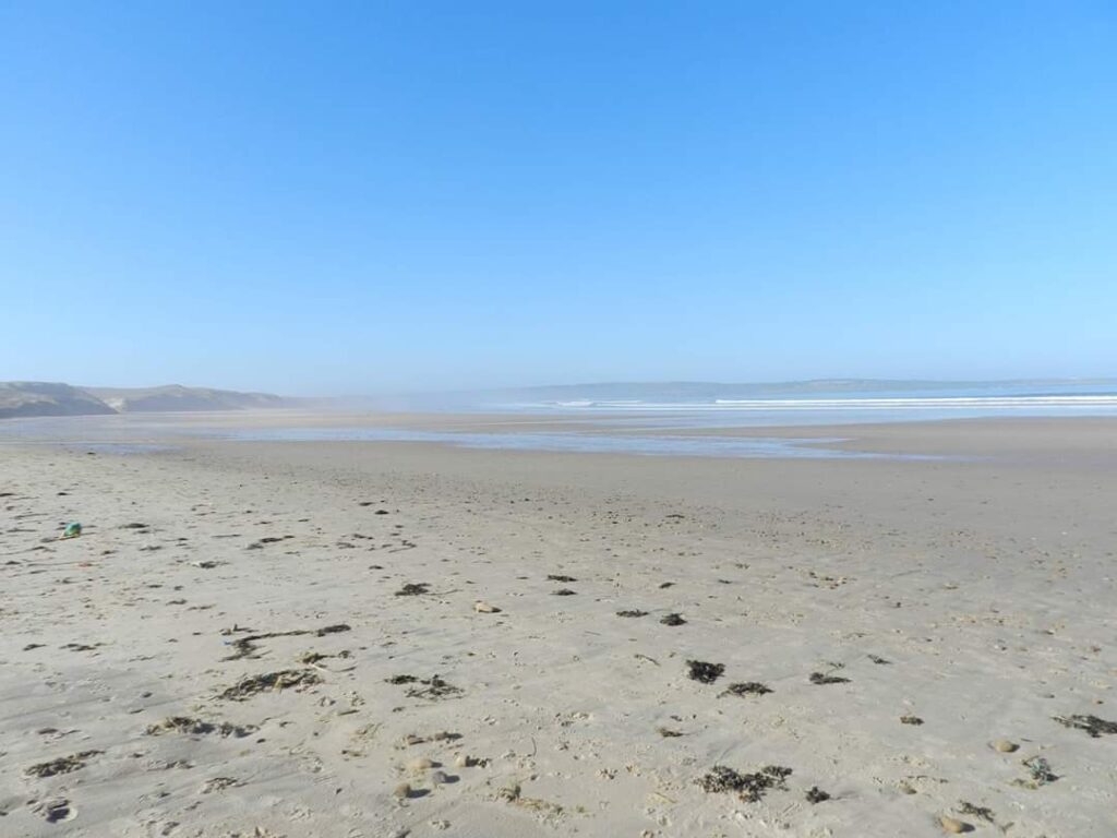 Miles of white sand with the sea in the distance