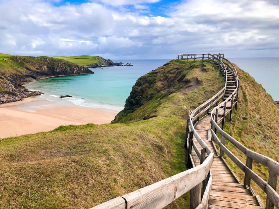 grass banks with walk way to the beach overlooking the turquoise sea