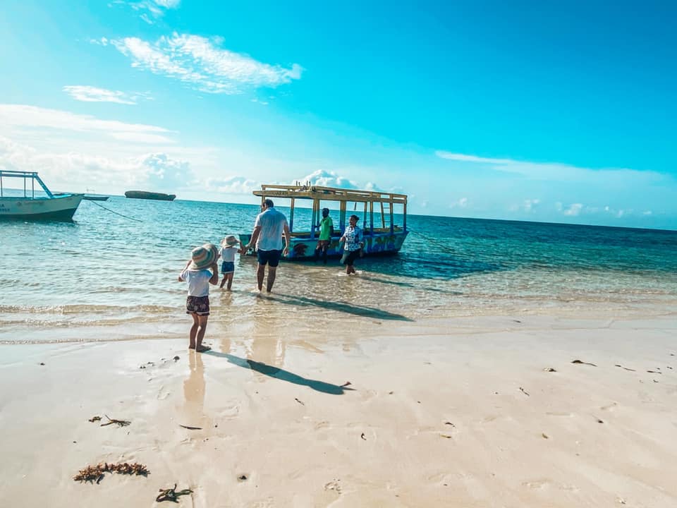 a family and children walking out to the boat