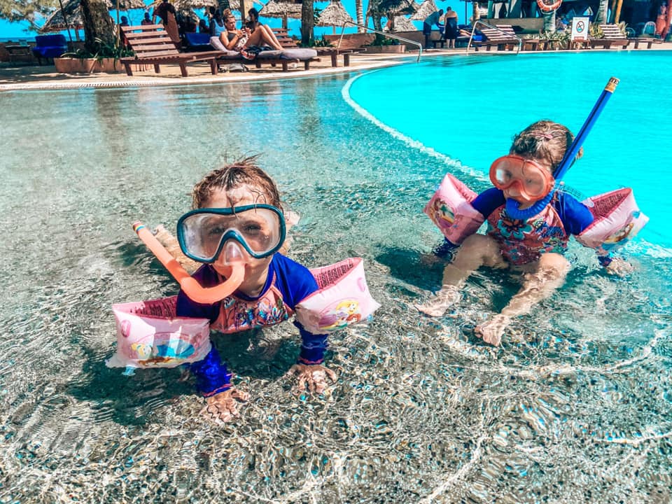 Two girls with snorkel gear on in the main swimming pool at turtle bay resort