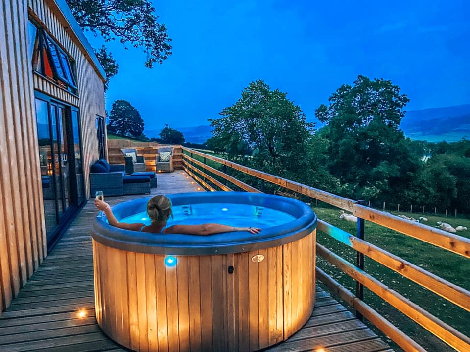 The hot tub at Penlan lodges after dark looking out over the fields