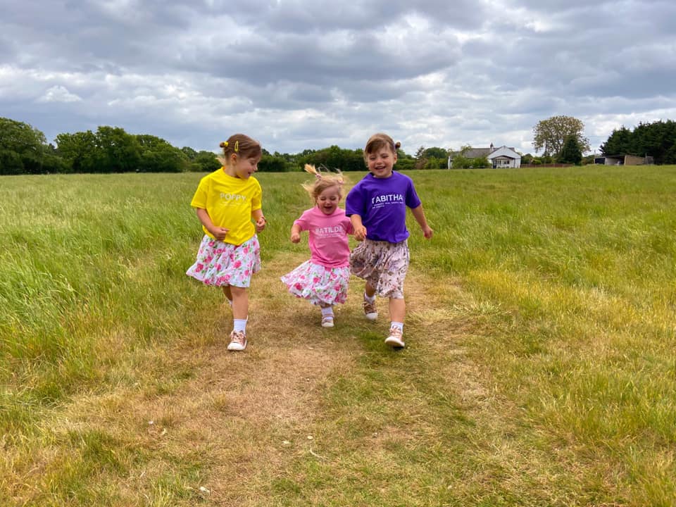 Three children running through fields