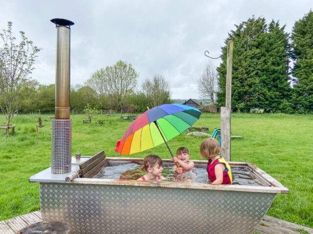 Glamping with a hot tub and grill playing in it in the rain