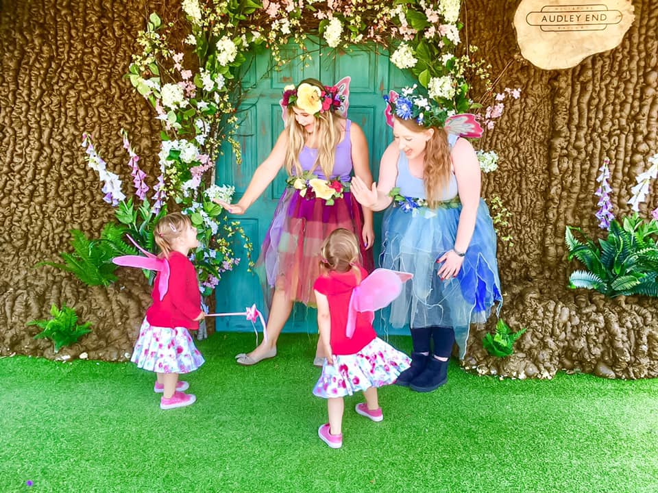 Three girls looking at a fairy house at Audley end days out in essex