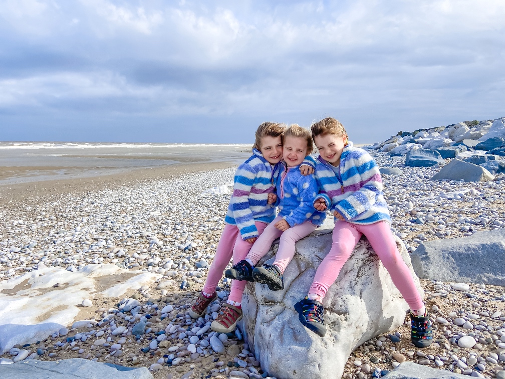 Away Resorts Golden Sands Rhyl three girls sitting on a rock on the beach