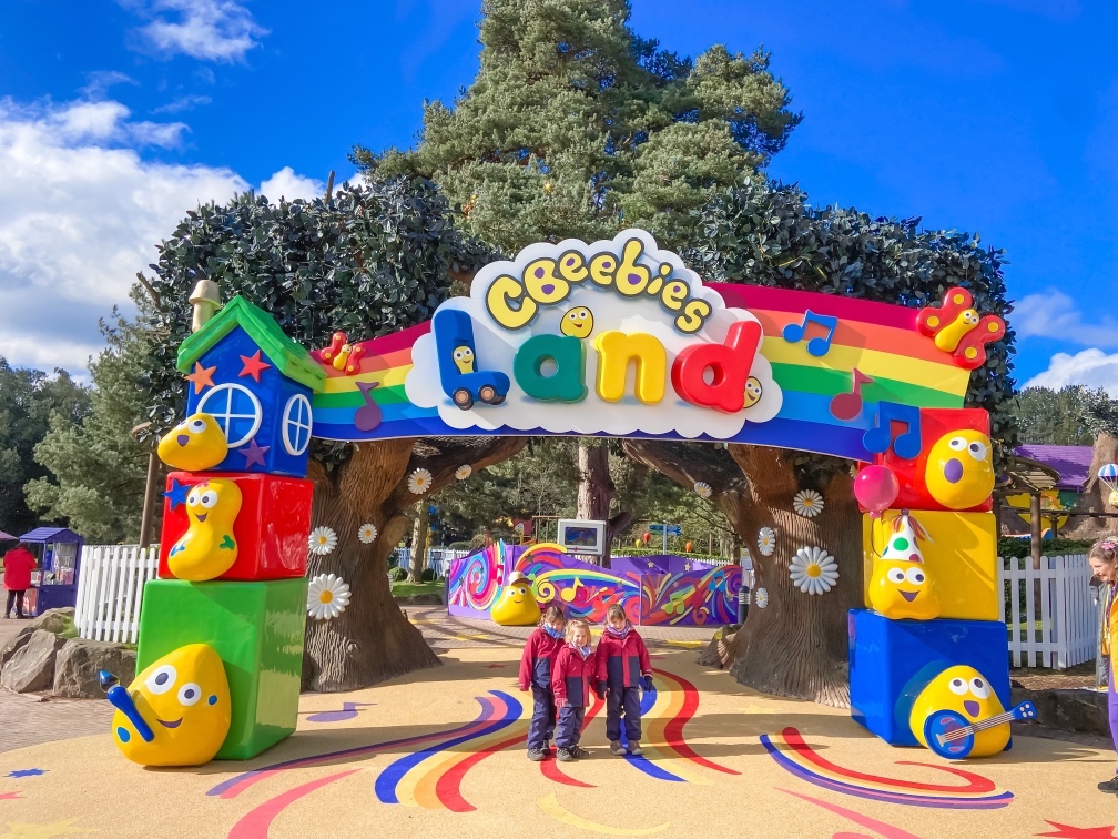 Cbeebies Land entrance with three young girls standing with their coats on