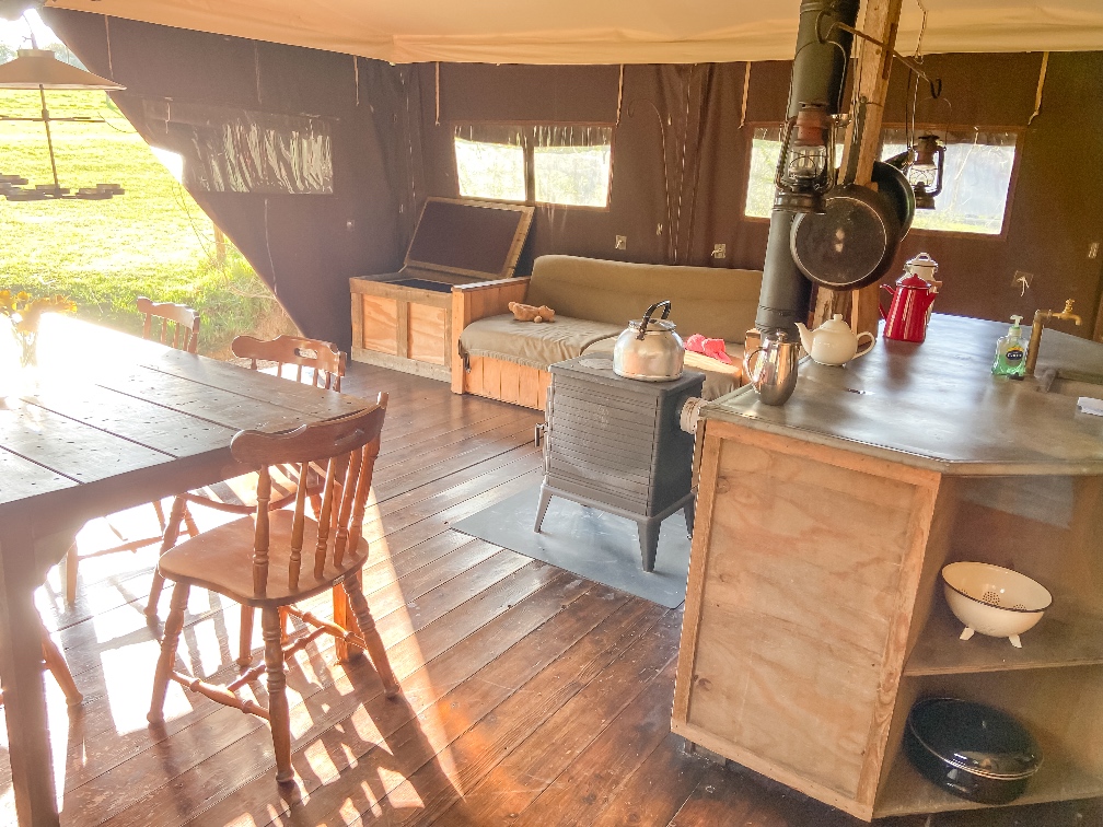 Glamping in Bedfordshire Featherdown living area with a table and chairs and a sofa 