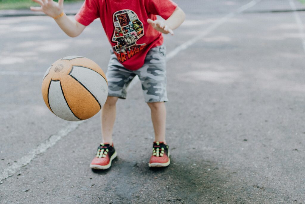 A boy playing basketball which is one of many great sports kids can play all year round
