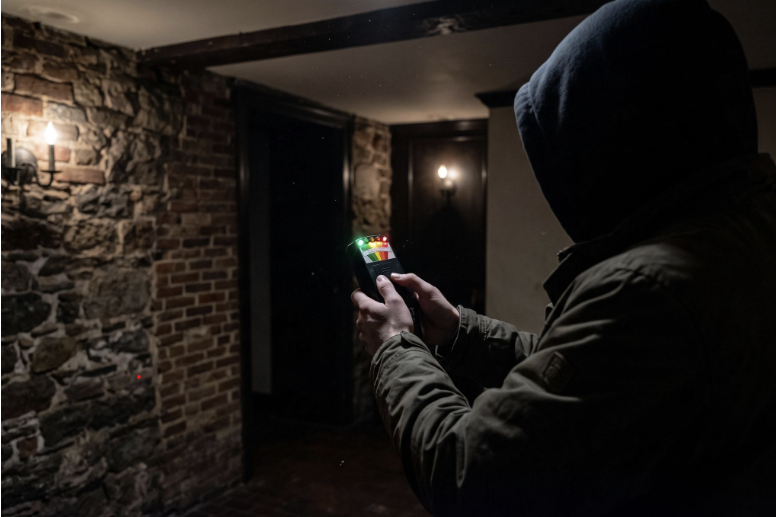 A tour guest using an EMF Detector in an old building.